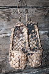 Footwear named lapty or bast shoes hanging on the wood wall (Sweden, Finland, Norway, Russia,...