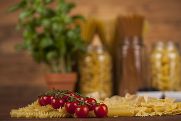 Dry pasta with ingredients on a old wood