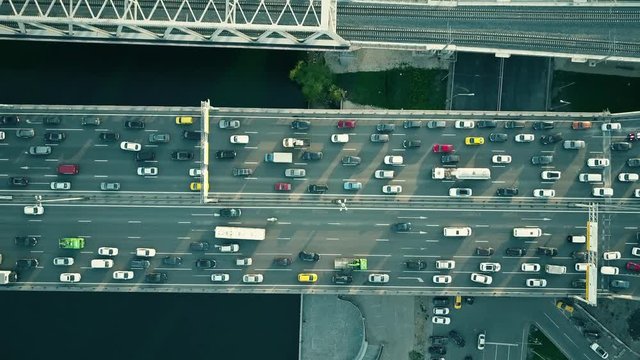Aerial top down view of traffic jam on a car bridge and moving train. 4K video