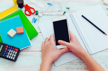 Teen girl with smartphone doing homework.  Distracted Talking On A Phone
