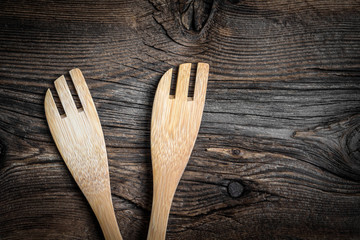 Wooden kitchen utensils on a wooden background. Copy space. Top view.