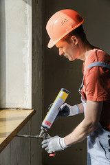 Worker is using a polyurethane foam. - obrazy, fototapety, plakaty