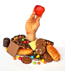 a hand with healthy stuff in it comes through a heap of sweets
