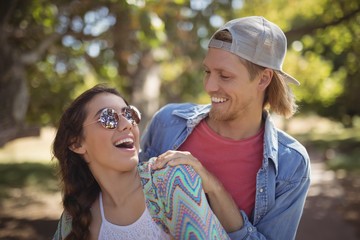 Close up of playful couple standing against trees