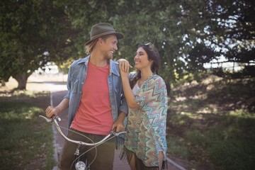 Romantic couple standing with bicycle