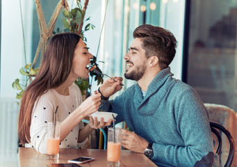 Happy couple at restaurant eating breakfast