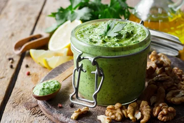 Fototapeten Pesto sauce with parsley and walnuts © yuliiaholovchenko