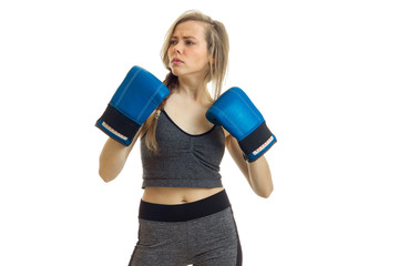 a charming young blonde-athlete stands in grey suit thoughtfully looks away and keeps near herself in Boxer