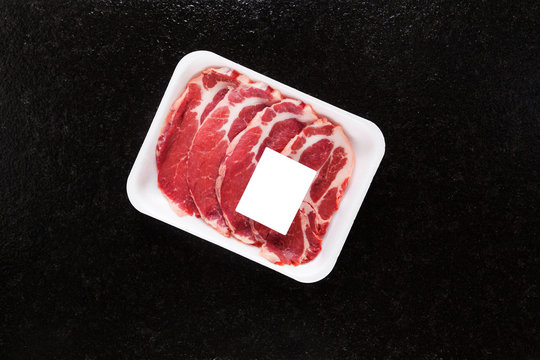 Meat In A Package Is Isolated On A Black Background