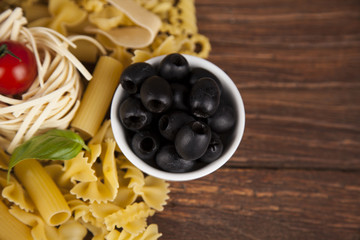 Dry pasta with ingredients on a old wood