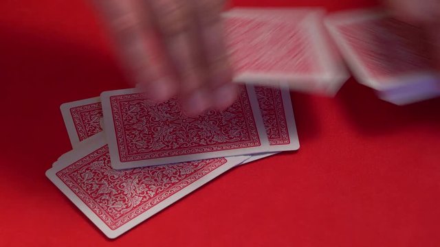 Croupier shuffling cards on gambling table.