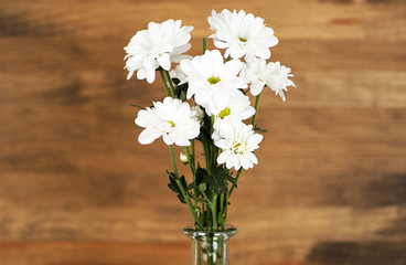 Flowers in a vase on a wooden table. Decor.