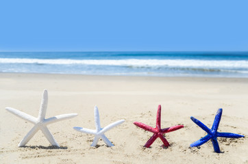Fototapeta na wymiar Patriotic USA background with starfishes on the sandy beach