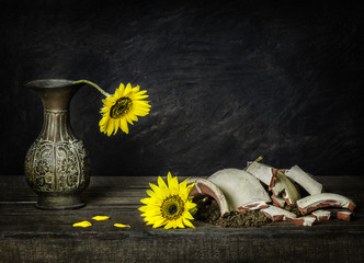 Classic still life with sunflowers placed on rustic wooden background.Brokenness concept © dinasaeed