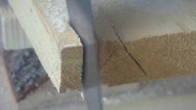 working with a handsaw sawing a wooden Board.