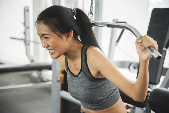 Asian woman in sportswear exercising with exercise machine at the gym.