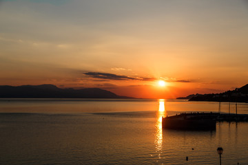 Fototapeta na wymiar Sun setting down over the sea, The red disc of the sun touches the horizon