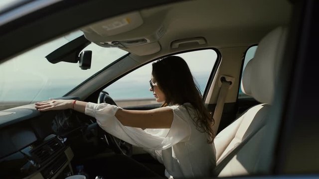 Charming brunette in sunglasses enjoy her luxury car