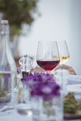 Close-up of red wine glass, salt and pepper shaker on table