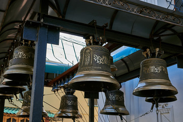 Bells with a beautiful ornament. Bells hung on a metal beam