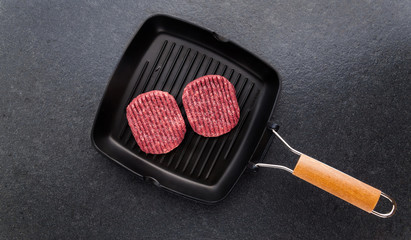Raw hamburger cutlet in a frying pan for grilling. Burger. Cooking food