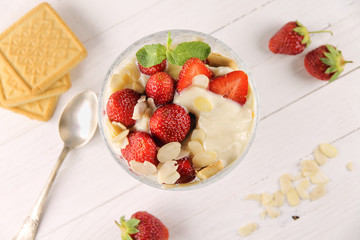 Strawberry dessert with yogurt, almond shavings and mint