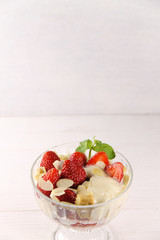 Strawberry dessert with yogurt, almond shavings and mint