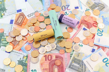 Euro Geldmünzen und Geldrollen auf Geldscheinen