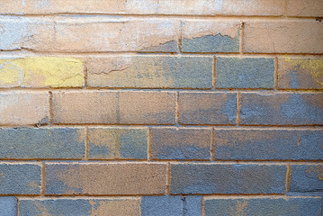 Aged worn-out wall with colored bricks. Background for interior design, advertising or illustration