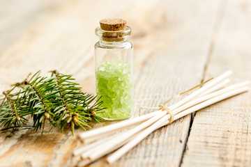 Bottles of sea salt and fir branches for aromatherapy and spa on white table background