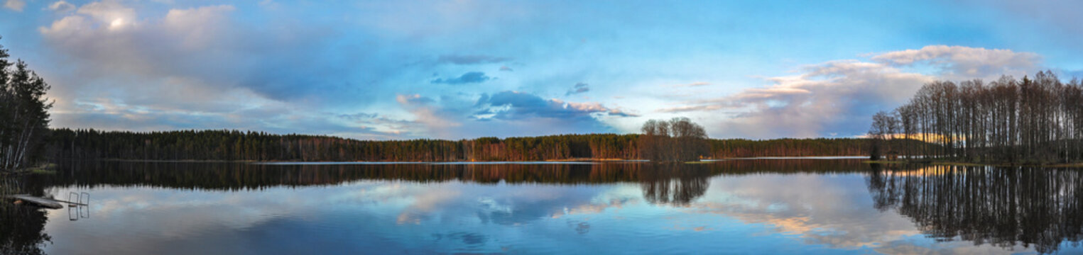 Panorama landscape. Borkovo lake at sunset, clouds reflection in the water.