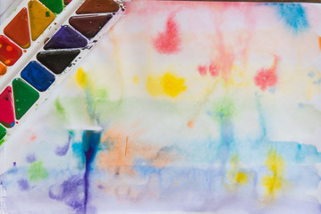 Multicolored watercolors on a white paper background
