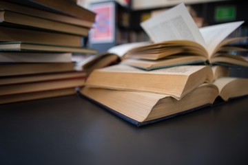 Close up of books on table against shelf in library