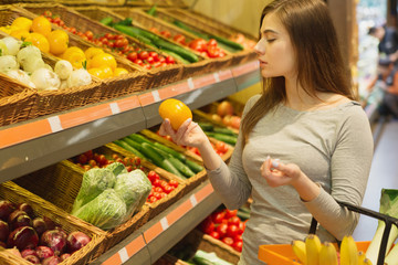 Beautiful woman shopping vegetables at the grocery store