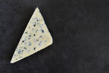 Slice of blue cheese on a black background