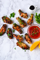 Chicken wings in orange sauce baked on a marble background