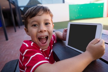 Portrait of cute boy holding digital tablet 