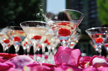 A slide of champagne with dry ice and smoke at the solemn event. Pyramid of glasses with alcohol and cherries.
