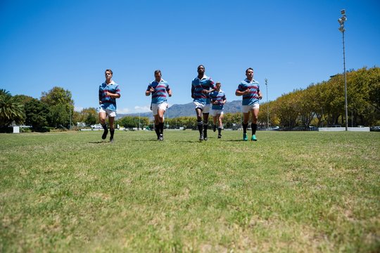 Confident rugby team running at field