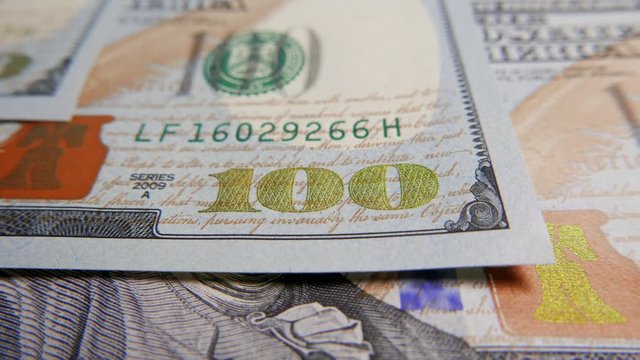 One hundred dollar bills close-up macro shot, tracking in