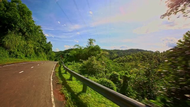 Camera Moves along Country Curvy Road among Hilly Landscape