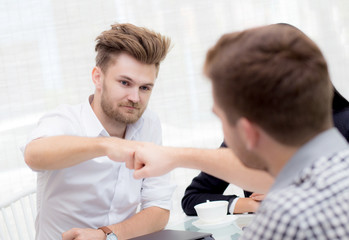 Fototapeta premium businessman giving fist bump after business achievement in meeting room - teamwork concept.