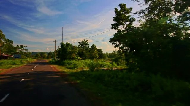Camera Moves along Shady Sunny Road among Rural Landscape