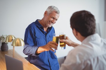 Two men toasting glasses of beer