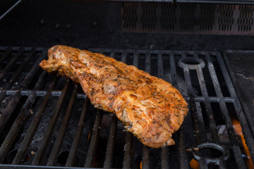 Pork ribs marinated and barbecued on a iron grill - side view