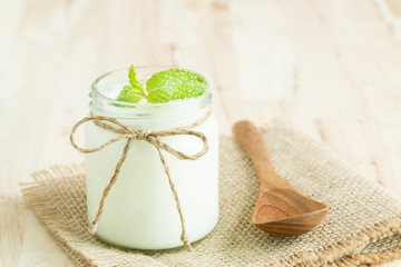 Yogurt in glass bottles on wooden table