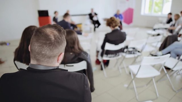 People looks as the speaker tells the interesting speech at business seminar