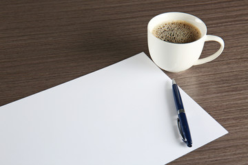 Empty paper sheet with pen and cup of coffee on table. Job interview concept