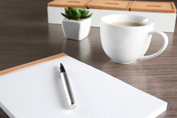 Empty notebook with pen and cup of coffee on table, closeup. Job interview concept