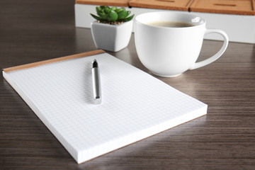 Empty notebook with pen and cup of coffee on table, closeup. Job interview concept